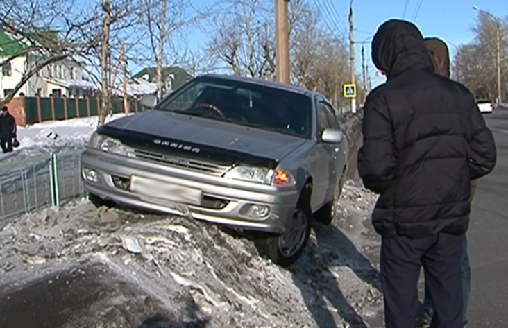 Иномарка с человеком внутри повисла на снежной обочине улицы Комсомольской