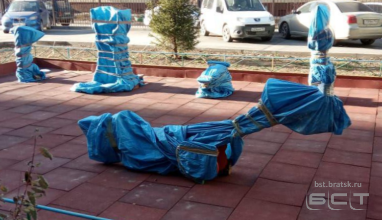 В новосибирском дворе качели и тренажёры замотали на зиму полиэтиленом. Угадайте, зачем?